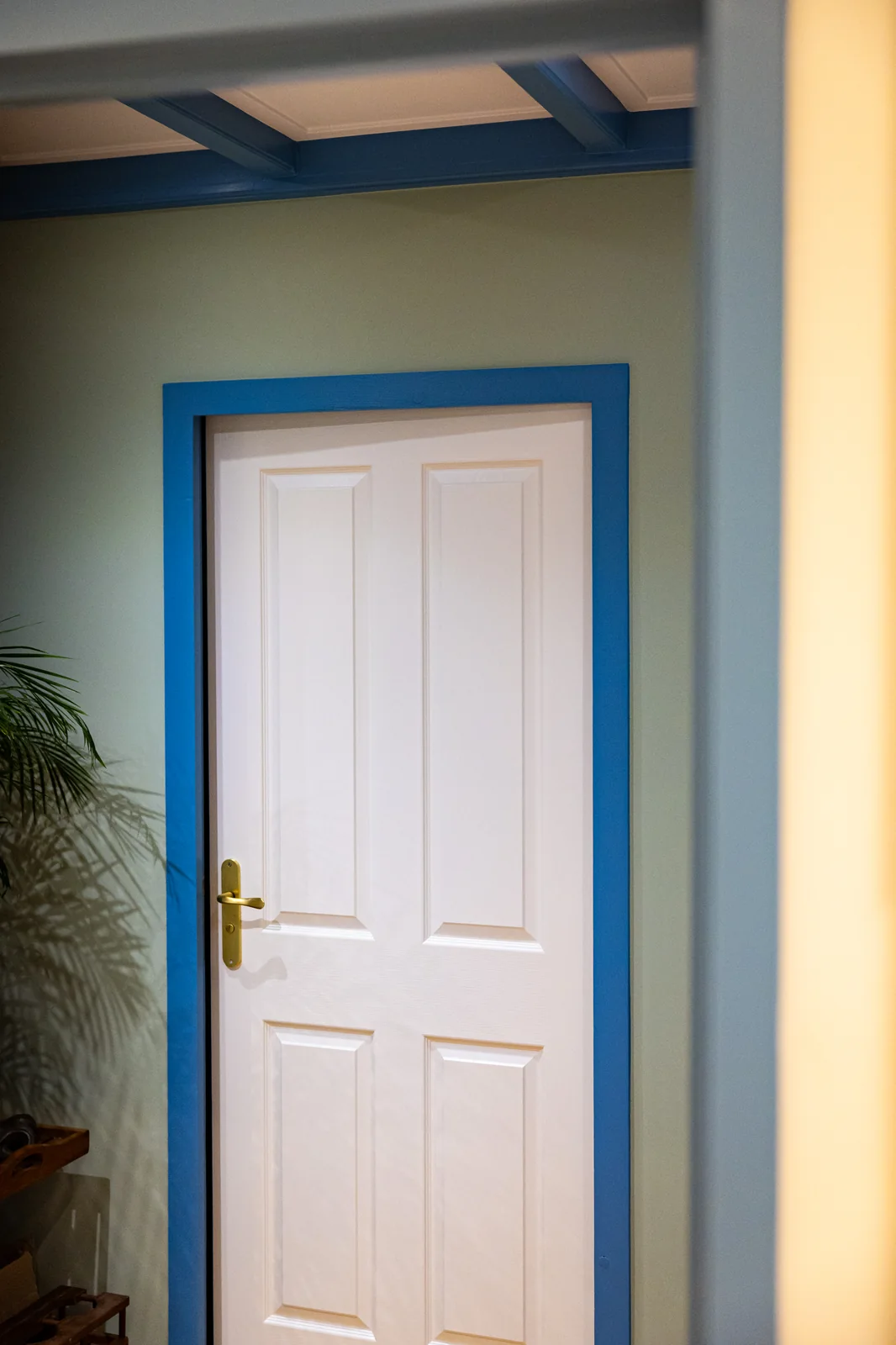 Strak geschilderde binnendeur met blauw kozijn